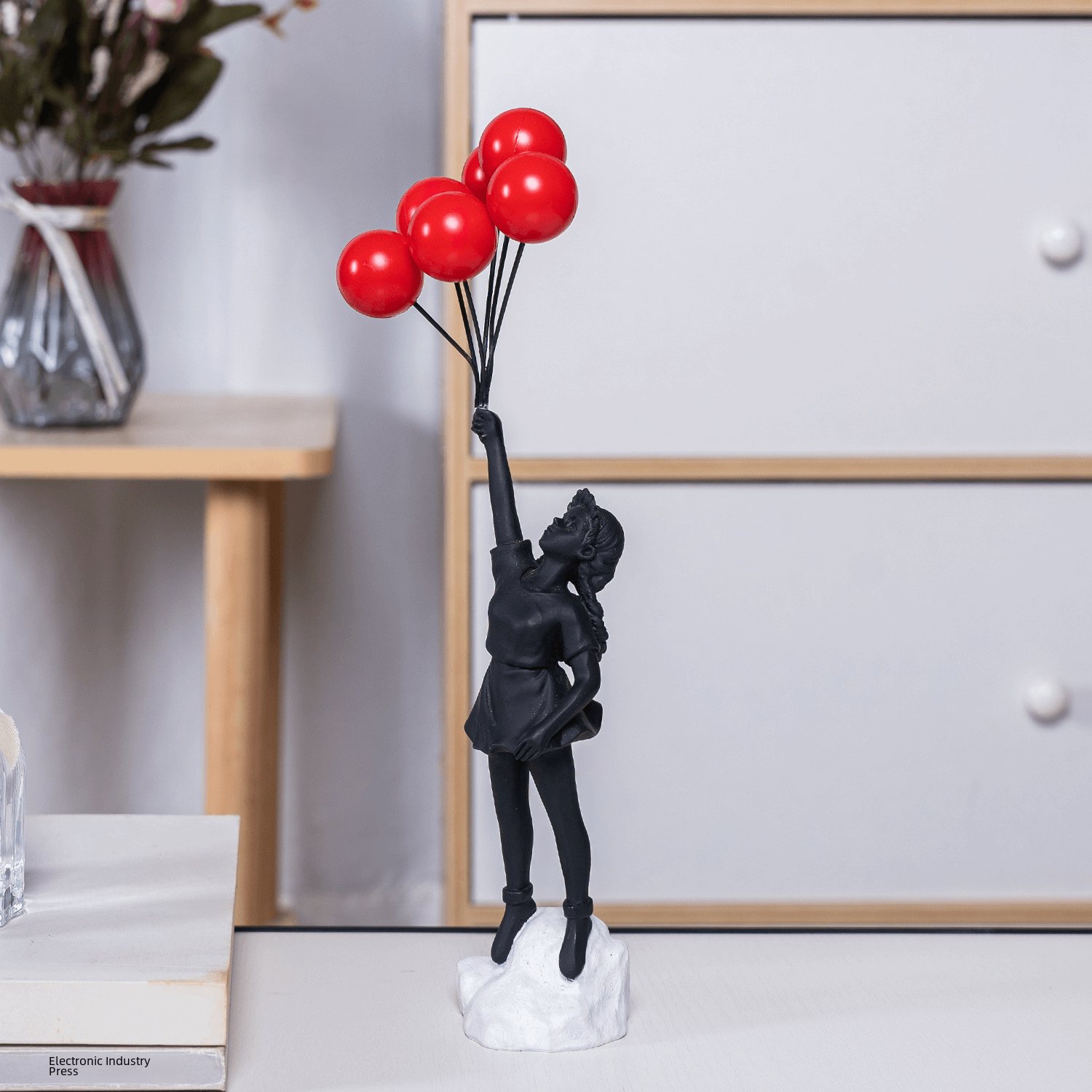 Pequena escultura em representação a arte girl with balloon do artista urbano Banksy.